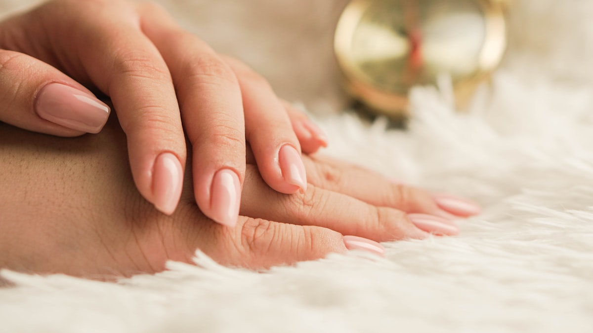 Nail technician finishing manicure